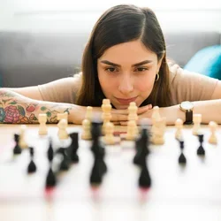 A young woman studying a chess board