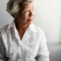 A woman in a white shirt looking off to the side